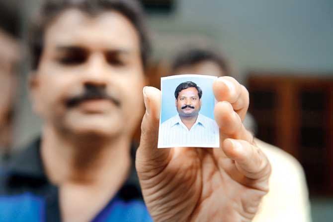 A relative holds up photo of Balaram, who is missing. File pic