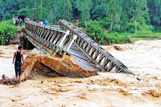 A bridge gets washed away in Thoubal District. Pic/PTI