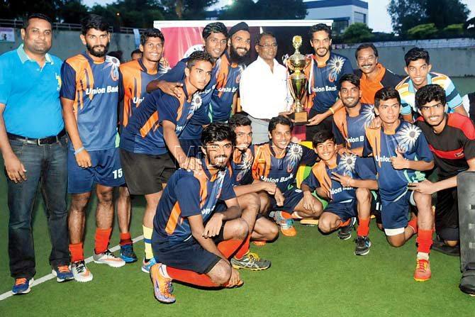 Ashok Kumar, son of legendary Dhyan Chand, presents the trophy to the victorious Union Bank of India team on Saturday. PIC/NIMESH DAVE 