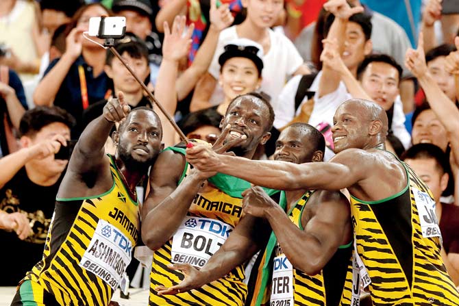 Jamaica’s Nickel Ashmeade (left), Usain Bolt, Nesta Carter and Asafa Powell (right) celebrate their 4x100 metres relay gold by taking a selfie after the final on Saturday. PIC/GETTY IMAGES