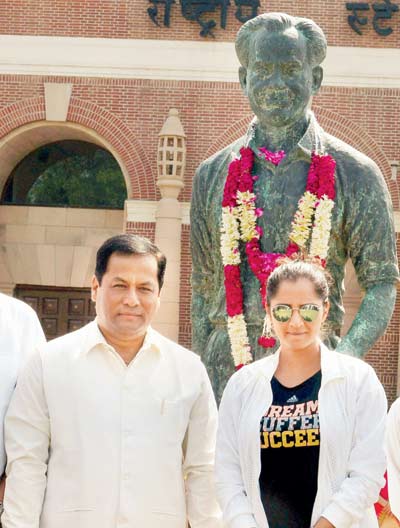 Sports Minister Sarbananda Sonowal with Sania Mirza during the birth anniversary celebrations of hockey legend Major Dhyan Chand (statue garlanded) in New Delhi on Saturday. PIC/PTI 
