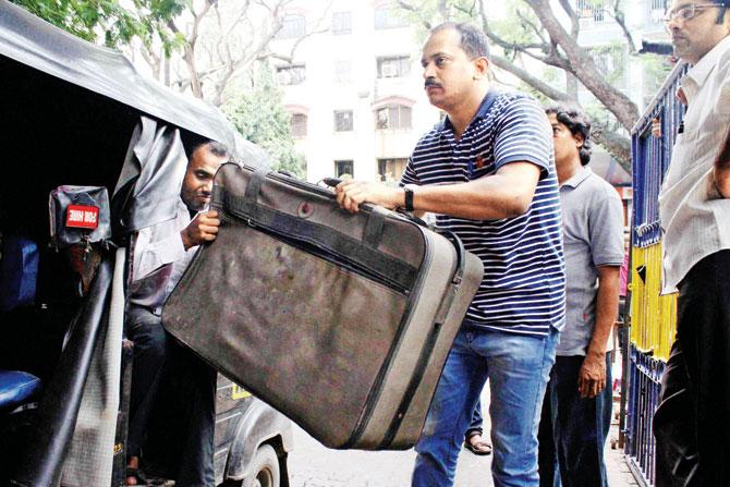 Officials haul away the suitcase that was recovered from the Worli residence. PIC/PTI