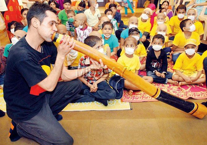 Australian artist Jack Buckskin plays the Didgeridoo, an Aboriginal musical instrument for cancer affected kids. PIC/ shadab Khan