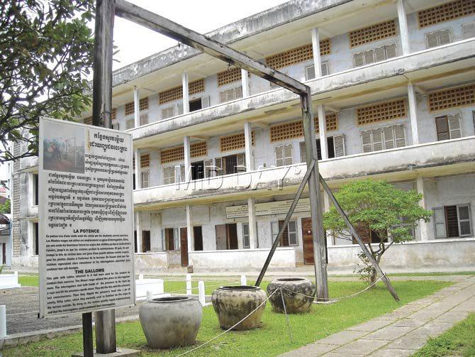 A view of the central complex. In the foreground are gallows where interrogators tied the hands of prisoners with a rope and lifted them, head down. They did this until the prisoners lost consciousness. They dipped the prisoner’s head into a jar of filthy water used as fertilizer for crops in a terrace nearby. This would ensure that the victims regain consciousness and interrogation could continue