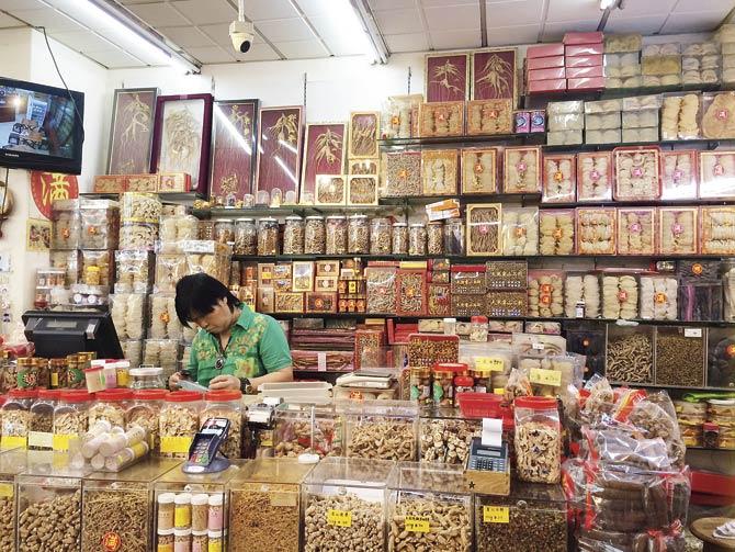 A man selling a wide range of Chinese ingredients in a department store past Bugis street, close to the famous Chinese temple. The stock includes sea cucumbers, dried scallops, herbs, dried fruit, peanuts, flowers, dried mango, candied orange peel, dried sour plum and dried rose buds used for flavouring Chinese tea among other things. Pics Courtesy/Irfan Pabaney
