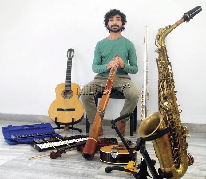 Jose Neil Gomes with some of the instruments that he plays; (From left to right) Melodica, acoustic guitar, glockenspiel, didgeridoo (in hand), nylon guitar, concert flute and saxophone. Pic/Nimesh Dave