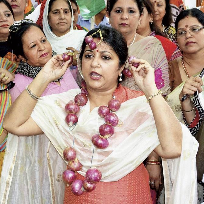 A member of the Delhi Pradesh Mahila Congress uses onions as ornaments to protest against the price hike of the vegetable, outside the BJP head office at Ashok Road in New Delhi yesterday. Pic/PTI