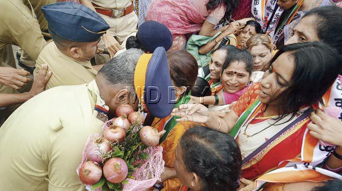 Members of the NCP women’s wing offer a bouquet made of onions to a police officer outside Mantralaya to protest against the skyrocketing prices of onion. Pic/Sameer Markande