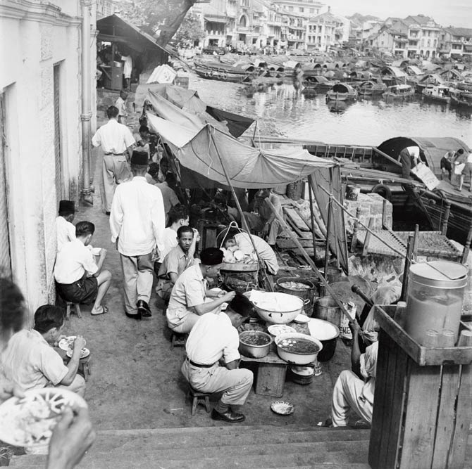 Street food and hawker centres aren’t a new fad in Singapore. This photograph shows customers dining at an open-air food stall on the waterfront in Singapore, 1957. Pic/Getty Images