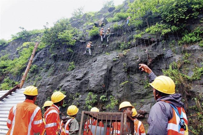 Repair works being carried out on the Mumbai-Pune Expressway after a landslide that occurred near Khopoli. Pics/PTI