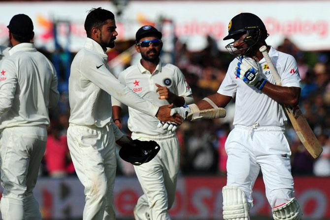 Sri Lankan cricketer Kumar Sangakkara (R) is congratulated by Indian cricket captain Virat Kohli (2L) and teammates after he was dismissed during the fourth day of their second Test cricket match between Sri Lanka and India at the P. Sara Oval Cricket Stadium in Colombo on August 23, 2015. Pic/AFP