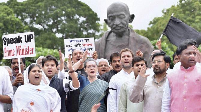 Congress President Sonia Gandhi, Vice President Rahul Gandhi (front row centre) and other MPs shout slogans during a protest against suspension of 25 party members, at Parliament in New Delhi. Pic/PTI