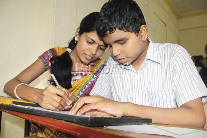 Vaishali Mahajan, a NAB-trained teacher, with Akhilesh Kambali, who has low vision. Kambali uses large print papers and contrast colours as tools to understand mathematical concepts. Pic/Sharad Vegda