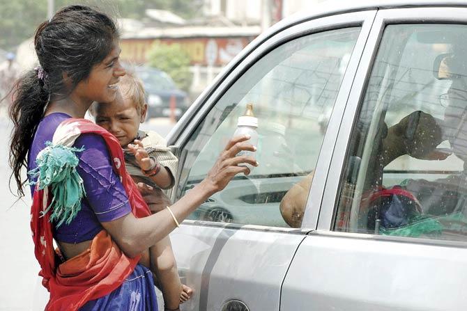 A woman begs for money in Amritsar to be able to buy milk for her child. Pic/AFP