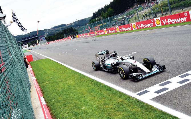 Mercedes driver Lewis Hamilton takes the chequered flag as he crosses the finish to win the Belgian Grand Prix yesterday. pic/afp