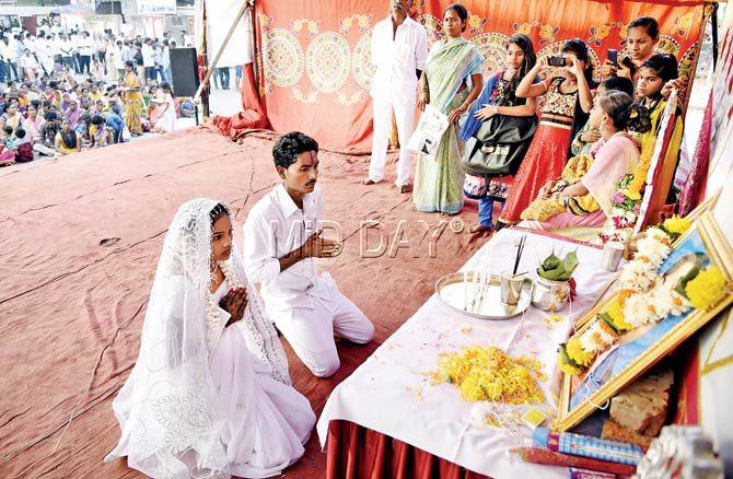 The newly-wed couple offers prayers at Buddha Vihar, the community hall at the base of the hillock where the Damu Nagar slum was located