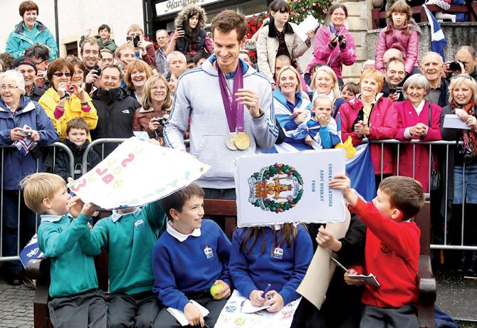 Andy Murray poses with local children in the centre of Dunblane, Scotland, on September 16, 2012, following his victory in the US Open and his gold medal in the London Olympics 2012. Pic/AFP