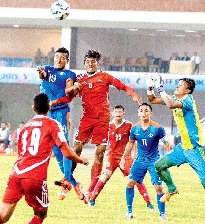 An Indian player (in blue) rises to head the ball ahead of a Nepal (in red) during their their SAFF encounter in Thiruvananthapuram yesterday. India won 4-1. Pic/PTI