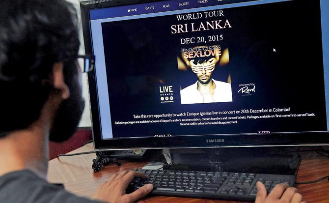 A Sri Lankan man checks the website of the event management company that organised the concert in Colombo