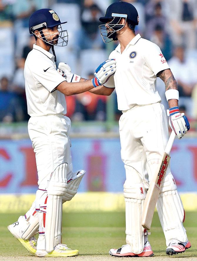 Virat Kohli (right) is congratulated by Ajinkya Rahane after the India skipper