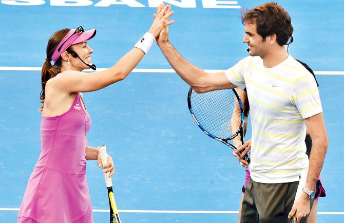Roger Federer (right) and Martina Hingis celebrate during an entertainment event in the Pat Rafter Arena on Day 1 of the Brisbane International tennis tournament in January 4, 2015. Pic/AFP