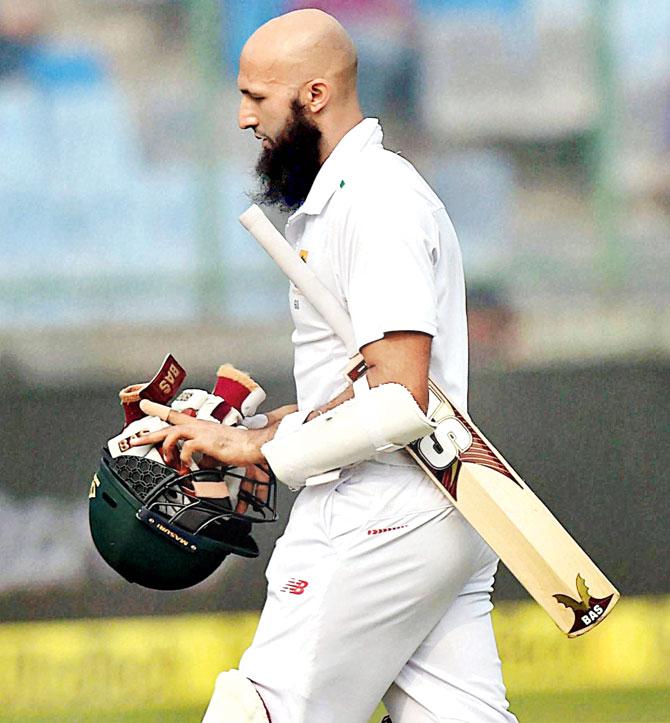 Hashim Amla walks back to the pavilion after being dismissed for 25 at Kotla yesterday. Pic/PTI