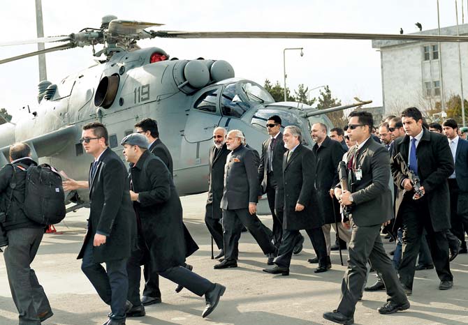 Indian Prime Minister Narendra Modi (6L) and Afghan Chief Executive Abdullah Abdullah (8L) walk past a Russian-made attack helicopter at the Kabul International Airport. Post Afghanistan, it was a visit to Pak that took everybody by surprise. Pic/AFP