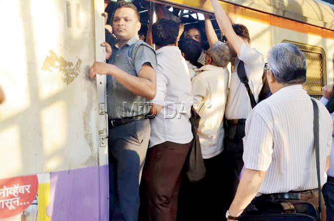 Commuters stand precariously on the footboard of the very compartment that Nakate had boarded that day. It is as overcrowded as it probably was that day. Commuters from the compartment said Nakate was not a regular in the 7.59 am local. Pics/Shrikant Khuperkar