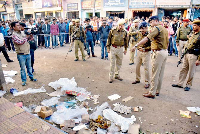 Police personnel investigating at the spot after a bomb blast took place at Fancy Bazar in Guwahati on Saturday. Pic/PTI
