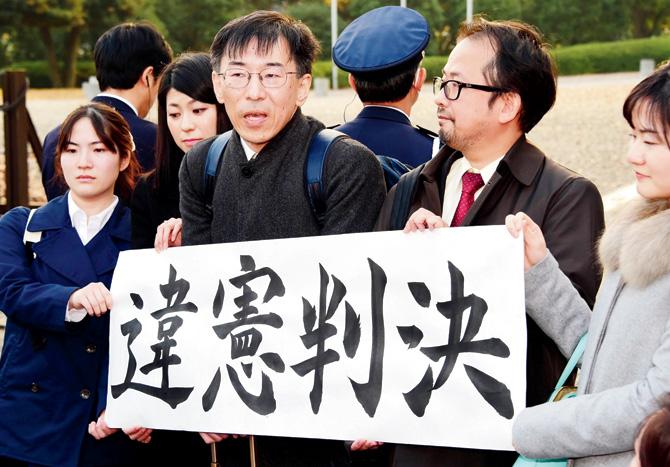 Lawyers and their supporters hold a banner which says “unconstitutionality judgement” outside of Japan’s Supreme Court in Tokyo yesterday. Pic/AFP