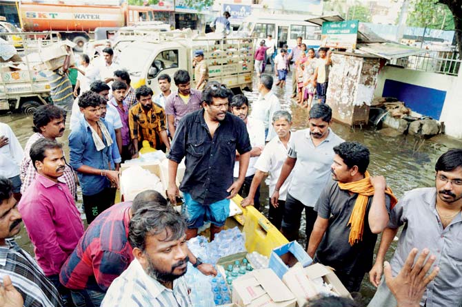 Tamil actor and director R Parthiepan helps flood victims at Virugambakkam in Chennai on Tuesday. Tamil Nadu’s film fraternity stepped up as one has never seen anyone do in India before, definitely not our rich fat cats of Bollywood. Pic/PTI