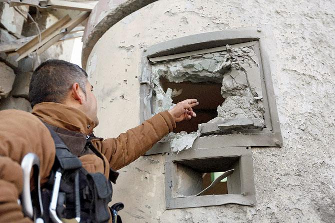An Afghan security guard inspects the damage at the Spanish Embassy in Kabul, Afghanistan, on Saturday. Pic/AP