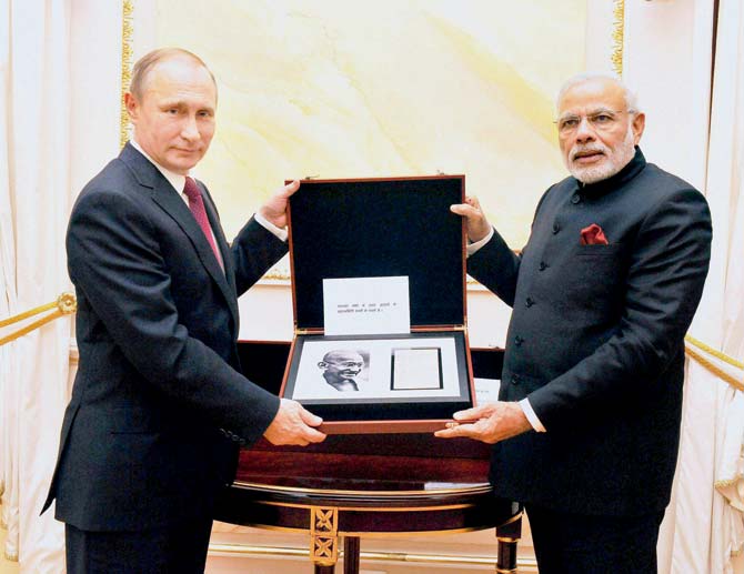 President of Russian Federation Vladimir Putin presenting a page that contains Mahatma Gandhi’s handwritten notes