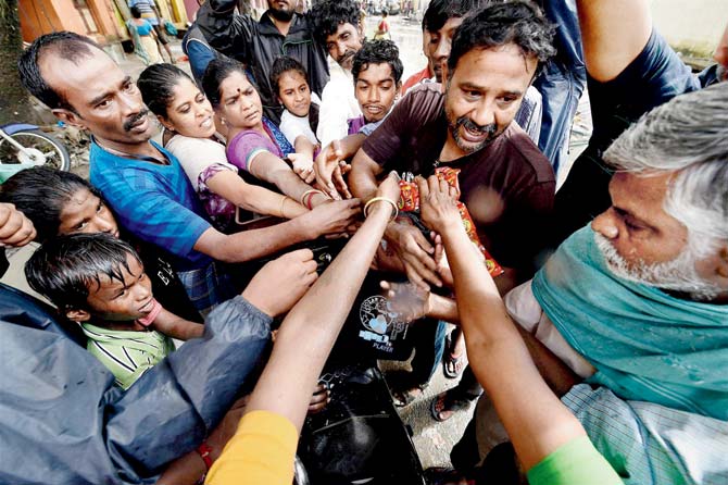 Volunteers distribute relief material in Kotturpuram, in Chennai, on Saturday. Pic/PTI