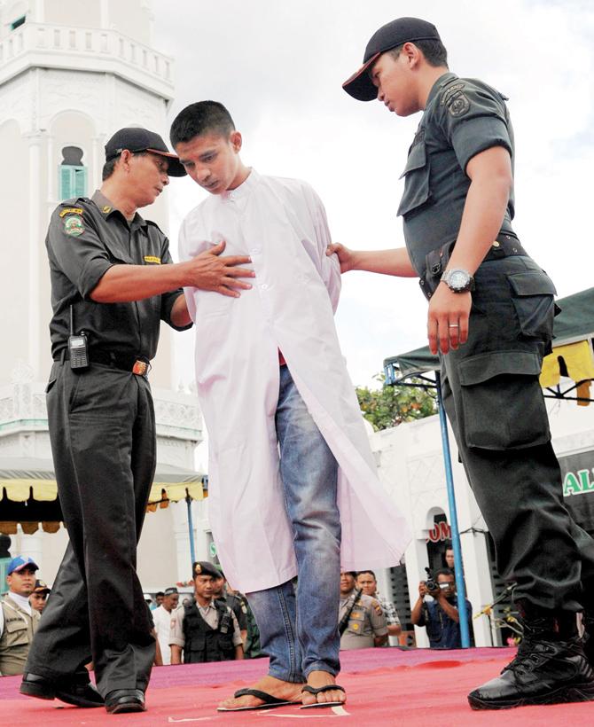 Wahyudi Saputra and Nur Elita were caned in public in the front yard of the Baiturrahim mosque in Banda Aceh. Pics/AFP