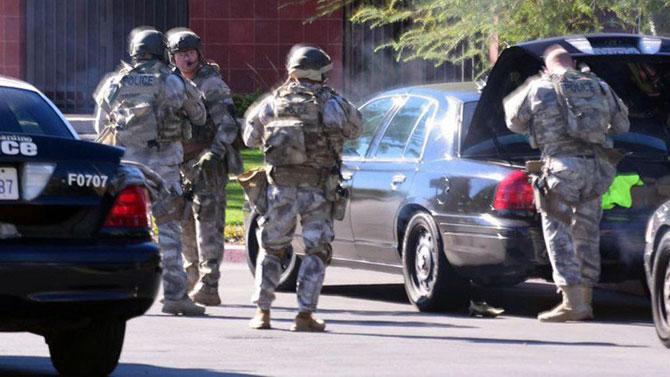 A photo made available by the San Bernadino Sun shows armed police officers at the scene of a fatal shooting in San Bernardino, California. AFP PHOTO / HANDOUT / DOUG SAUNDERS / SAN BERNARDINO SUN