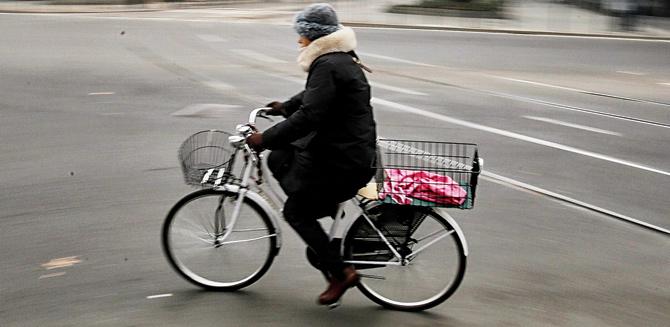 A woman rides her bicycle in central Milan after the ban on cars. Pic/AFP