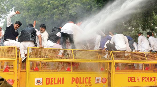 Holding fort: Delhi cops use a water cannon to disperse activists of the Youth Congress atop a police barricade — shouting slogans against the Modi-led NDA government — during a protest march against growing intolerance in New Delhi yesterday. Pic/PTI