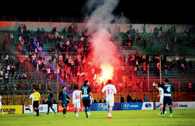 Fans light flares during an Egyptian Premier League match between Zamalek and ENPPI at the Air Defense Stadium in Cairo. Pic:AP/PTI