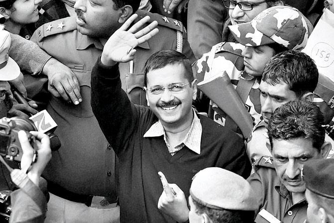 (Top) Flanked by policemen, Arvind Kejriwal waves after casting his vote for the assembly polls in New Delhi on Saturday. His party, Aam Aadmi Party, scored a historic victory in the elections as the results were declared on Tuesday. PIC/ PTI 