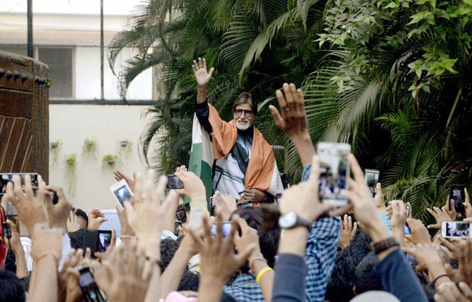 Amitabh Bachchan waves to the fans with the Indian Tricolour draped on his shoulders 