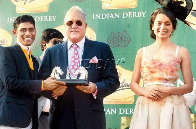 Jockey Suraj Nareddu (left), who rode Be Safe to the Indian Derby title, receives his trophy from UB Group chaiman Vijay Mallya while actor and chief guest Kangana Ranaut (right) looks on