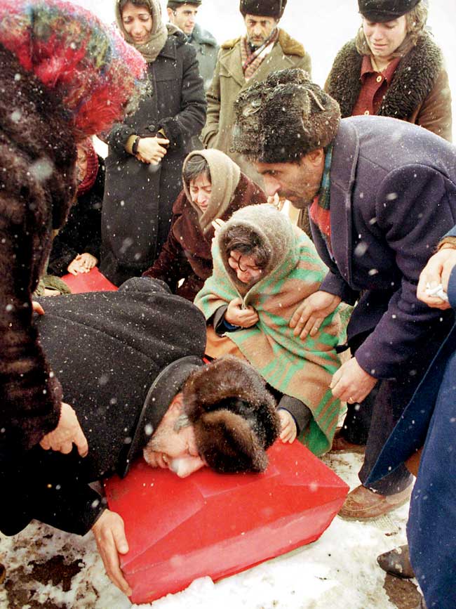 Family members grieve around the coffin of a child killed in an earthquake that shattered Armenia in December 1988. More than 25,000 people died in the quake. Pic/1988, David Turnley, World Press Photo of the Year