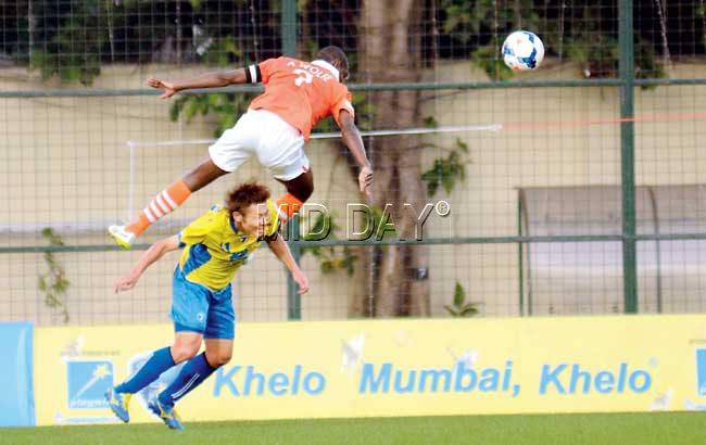 Taisuke Matsugae of Mumbai FC (yellow jersey) and Anthony Wolfe of Sporting Clube de Goa vie for the ball during their I-League encounter at the Cooperage yesterday. Pic/Atul Kamble