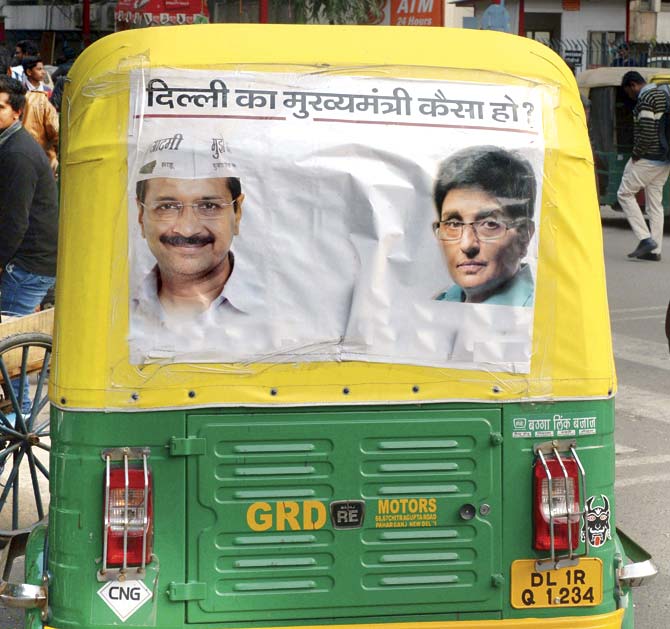 An auto rickshaw in New Delhi sports an elecion poster of the two front runners for the CM’s post AAP’s Arvind Kejriwal and BJP’s Kiran Bedi. PIc/AFP