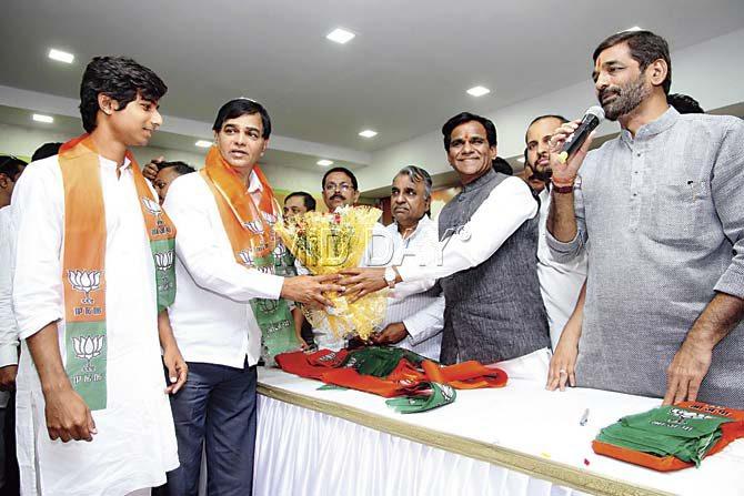 Ravindra Angre and son Rishikesh being inducted into BJP by Maharashtra party chief Raosaheb Danve on February 1. Pic/Sameer Markande
