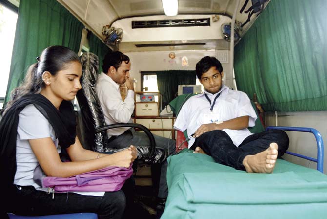 Sudarshan Shetty, a student of Shardashram Vidyamandir Junior college who met with an accident before appearing for his HSC exams, sat in an ambulance and wrote his answer paper with the help of a writer. File picture for representation