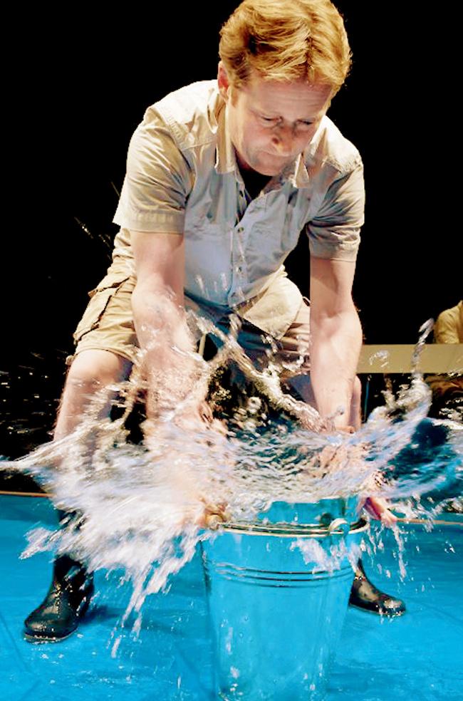 A performer interacting with a bucket of water in H2O