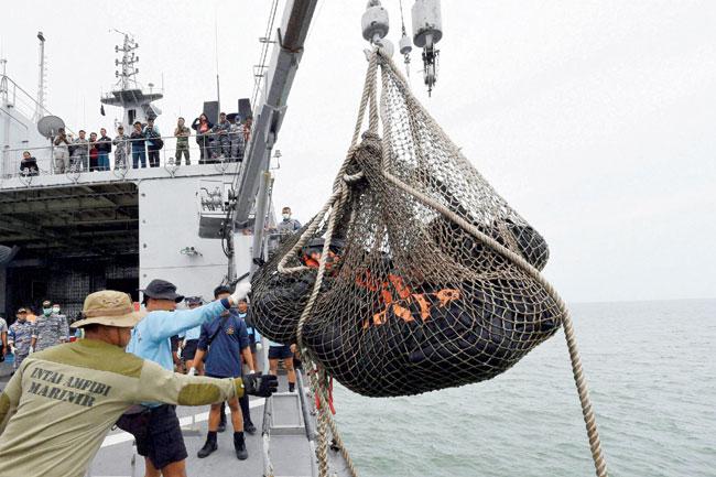 Dead bodies of victims of AirAsia Flight 8501 are lifted to Indonesian navy vessel KRI Banda Aceh at sea off the coast of Pangkalan Bun, Indonesia, yesterday. pic/ap