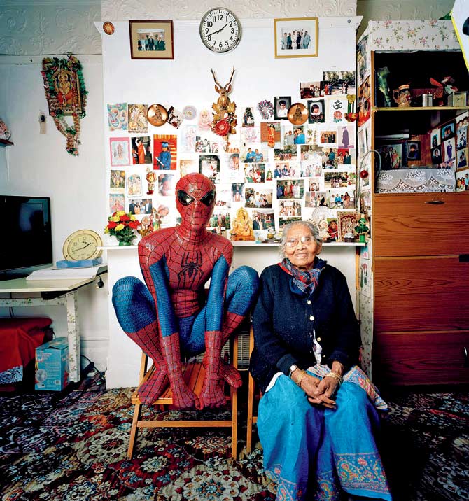 Baa’s House, a photograph that is part of the exhibition, showcasing Hetain Patel (in the Spider-Man costume) sitting with his grandmother in her living room in Bolton UK, where he was born